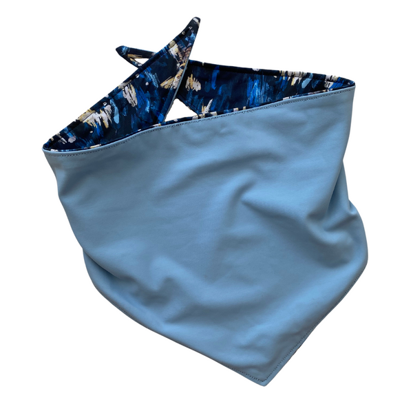 Close up picture of reversible dog swim scARF, aka cooling bandana for dogs. Showcasing a light blue color on one side and an abstract navy blue print on the other side. Pipevine Designs.
