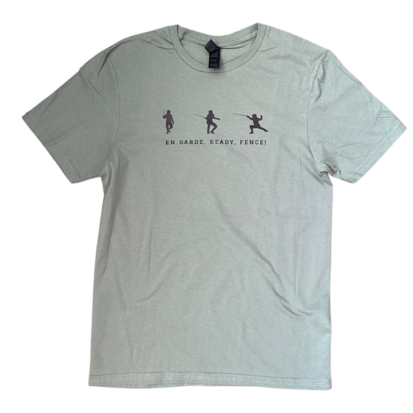 A sage green shirt, featuring three silhouetted fencers, each one in a different fencing stance. The positions include the classic stance, a slightly lower and readier stance, and the full extended lunge. The words, "En Garde, Ready, Fence!" hover beneath, narrating the scenes above. Adult shirt.