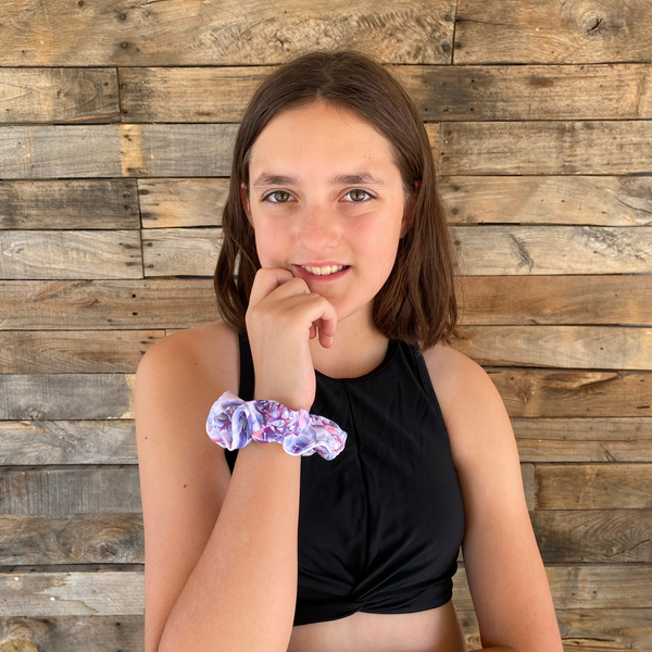 close up picture of pastel roses swim scrunchie on wrist of owner. Pipevine Designs