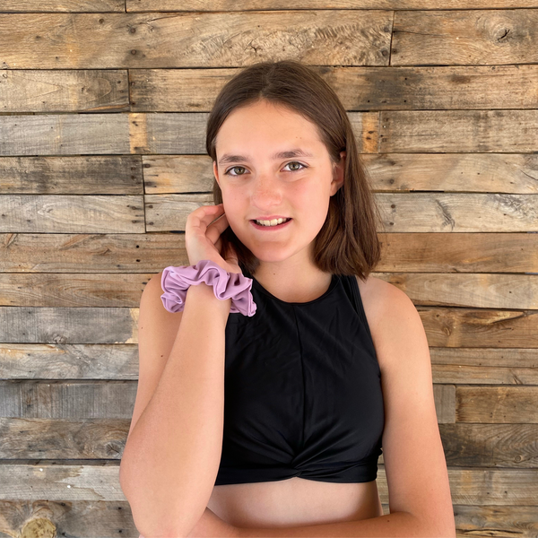 Close up picture of solid lavender swim scrunchie on wrist. Pipevine Designs.