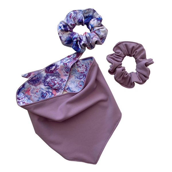 A close-up view of a Reversible Lavender and Pastel Rose Print Dog Swim scARF. The scARF features a soft lavender side on one half and a charming pastel rose print on the other half. Pictured with two swim scrunchies in the same prints