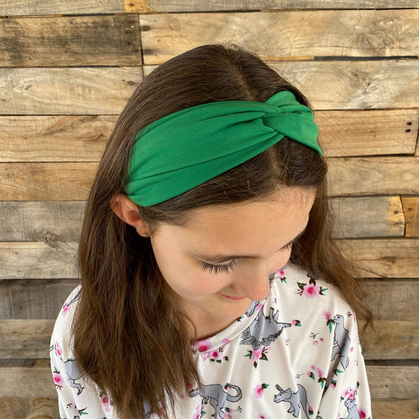solid kelly green faux knot twist headband on head top view